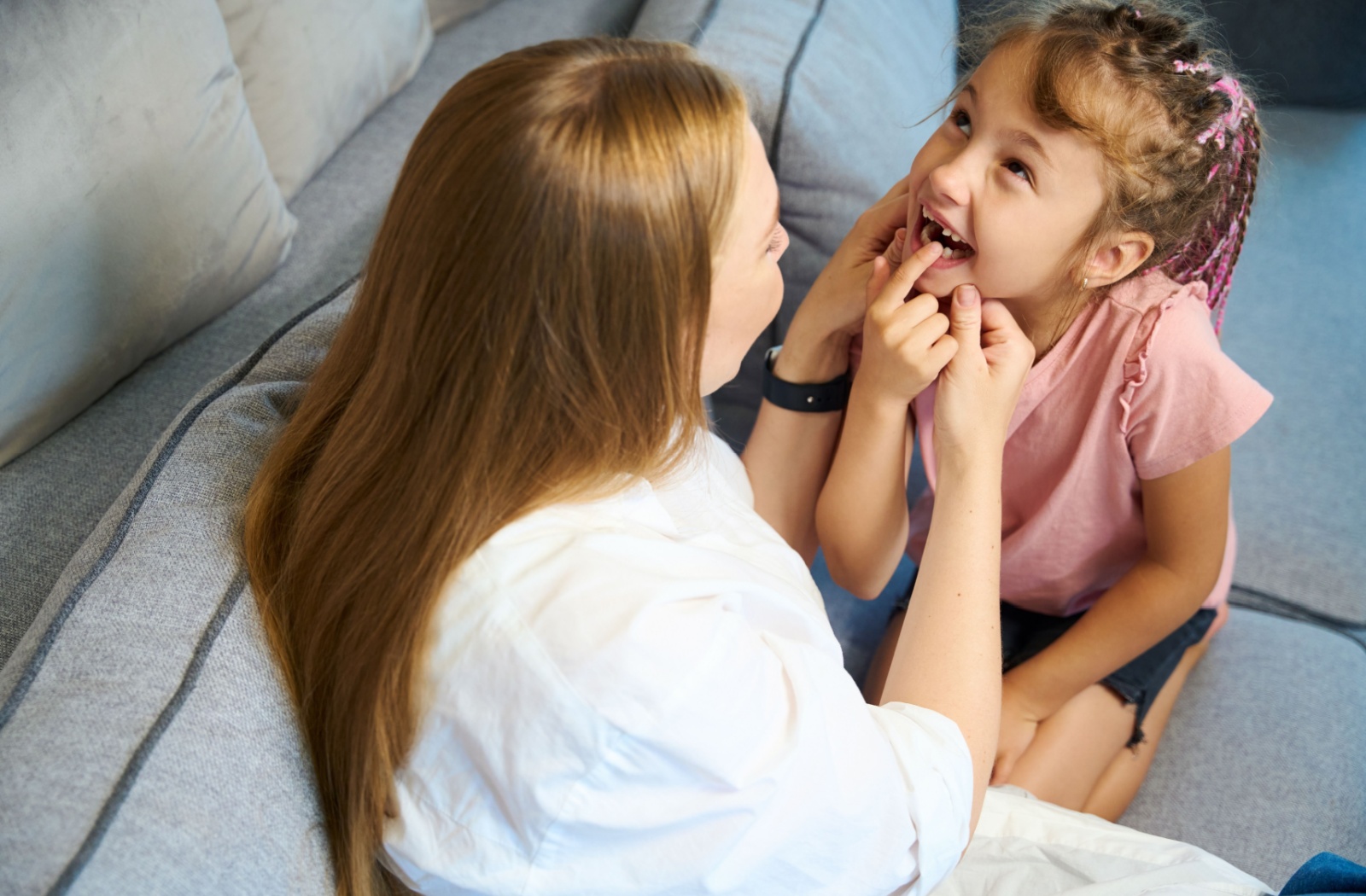 A mother looking at her child who is showing her a bottom tooth that has fallen out